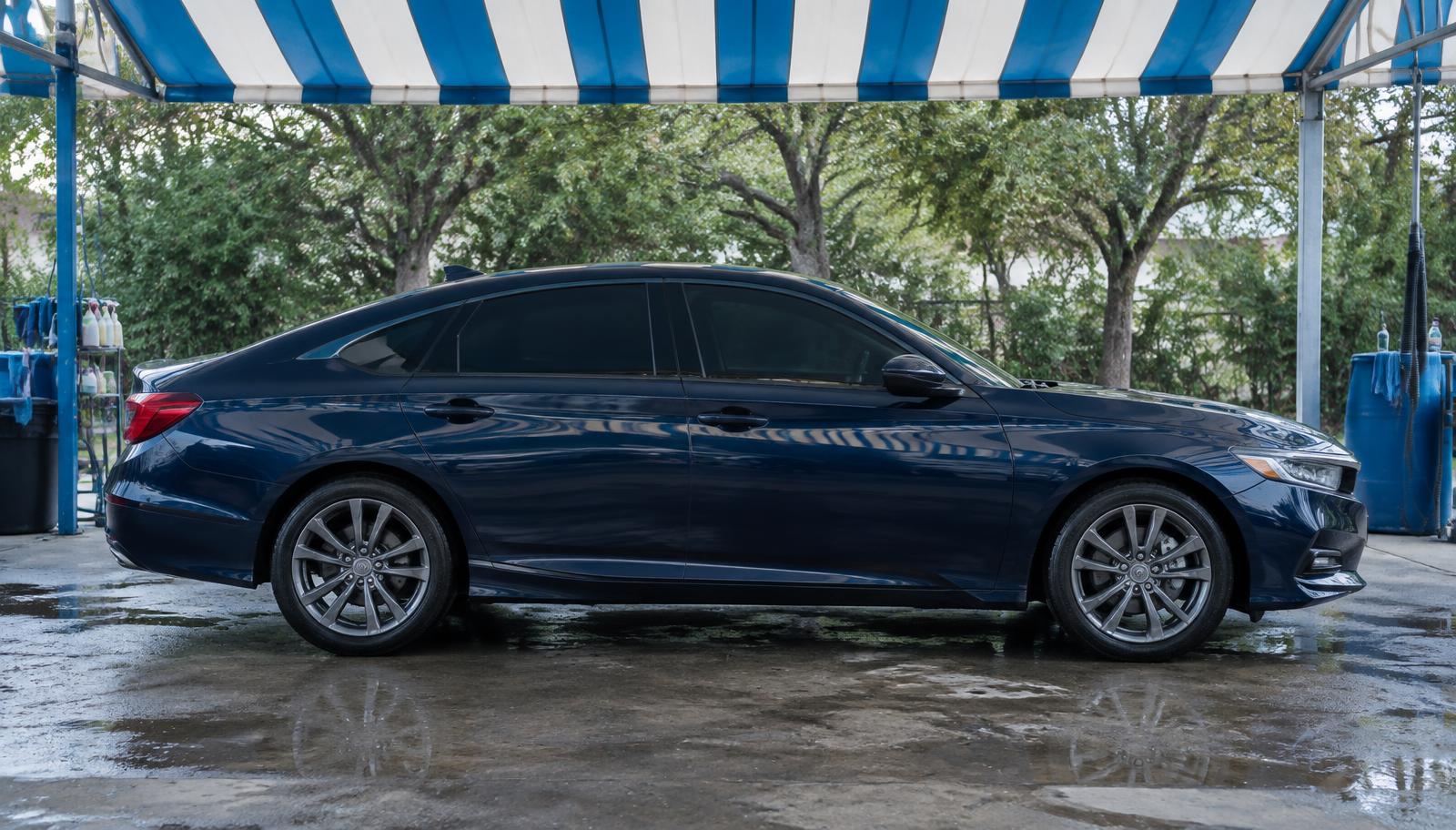 Navy sedan with tinted windows under the wash bay awning